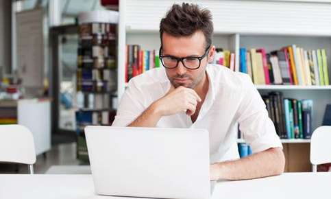 Image of a man wearing glasses reading. 