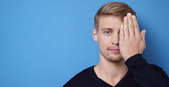 Image of man covering one eye. 