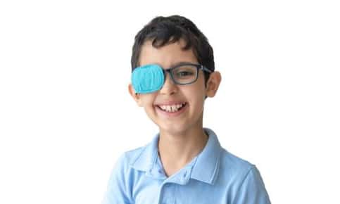 A young boy wearing an eye patch to treat amblyopia.