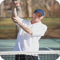 image of man at a tennis court holding his elbow