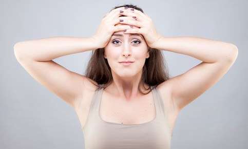 Image of a woman holding her face. 