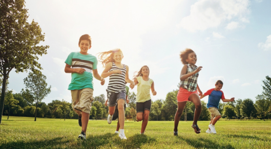 Children running together in a field.