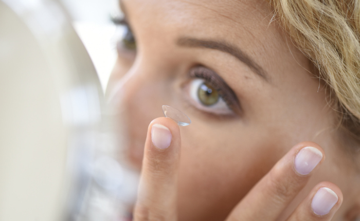 Woman puts in her contact lens.