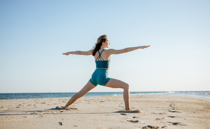 Woman does yoga on the beach.