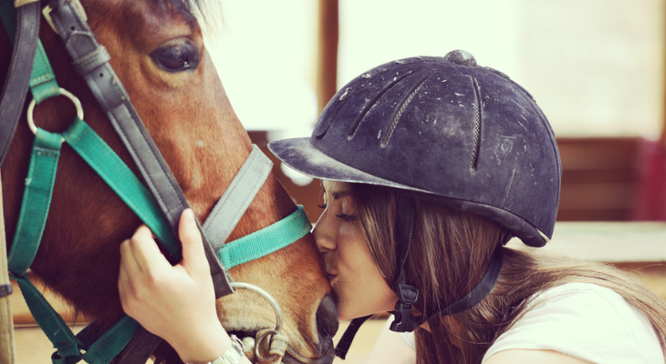 Girl kisses horse.