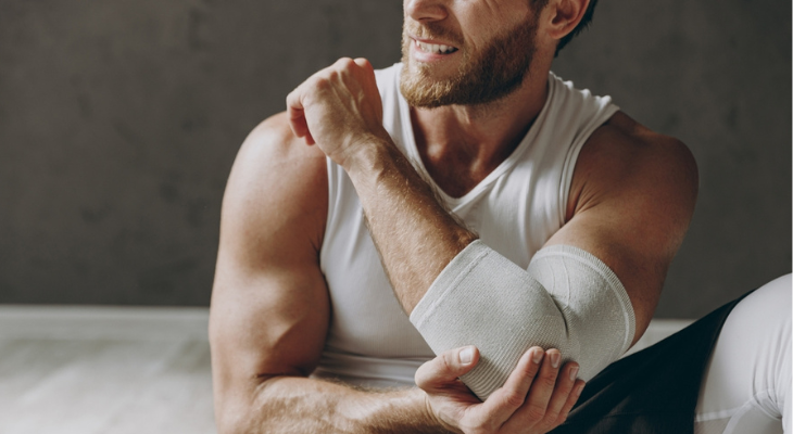 Man has elbow pain after overuse sports injury.