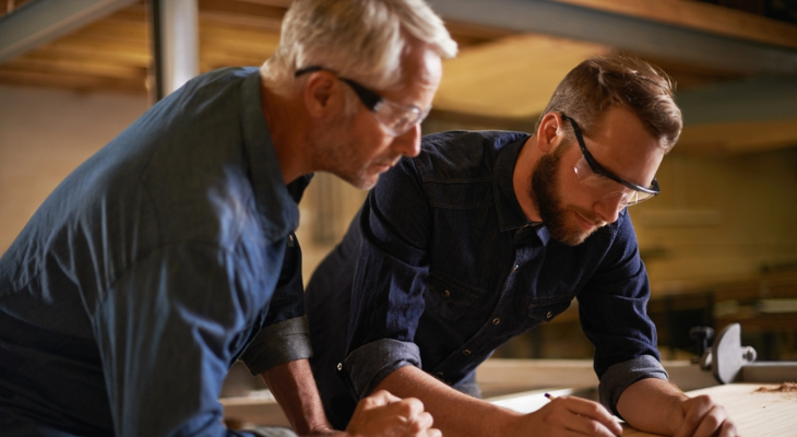 Two men work while wearing safety glasses.