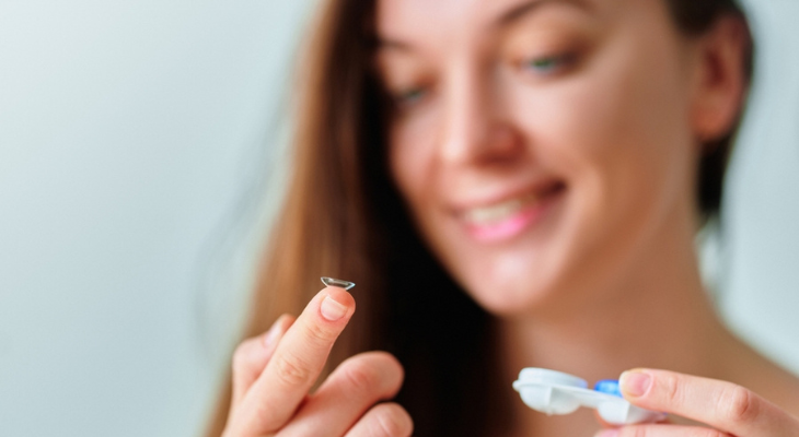 Woman prepares to put in her contact lenses.