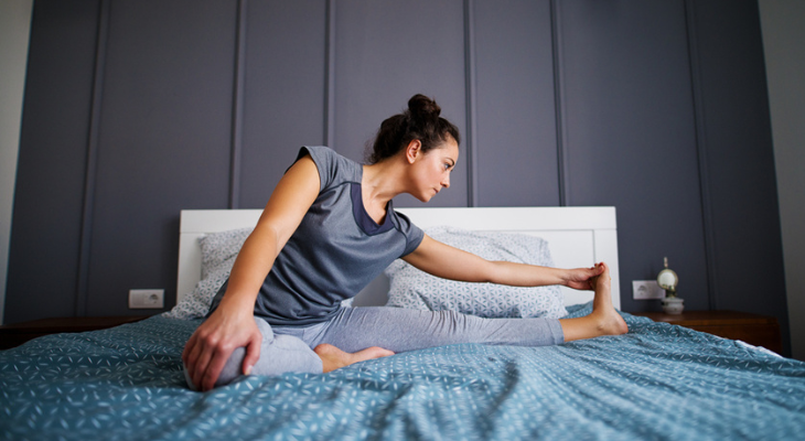 Woman stretches in bed