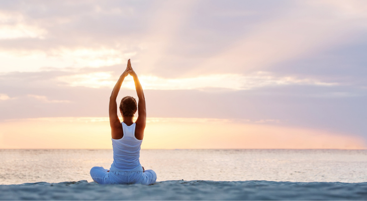 Woman doing yoga at the beach