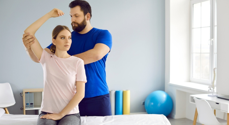 Chiropractor adjusts woman's shoulder