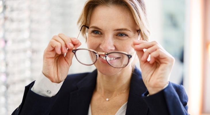 Woman takes off her glasses.