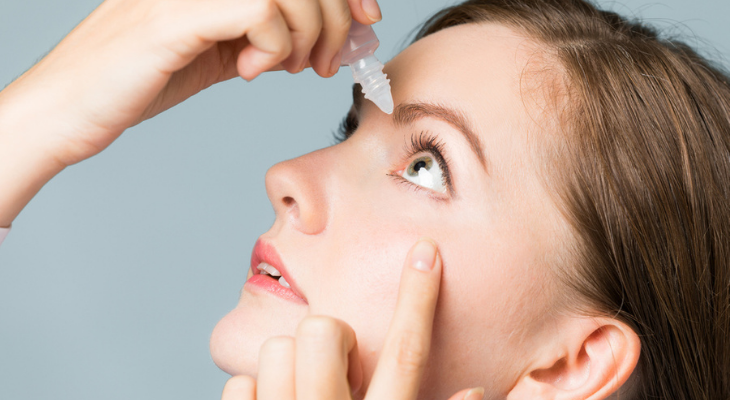 Woman applying eye drops