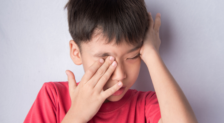 Little boy rubbing eye