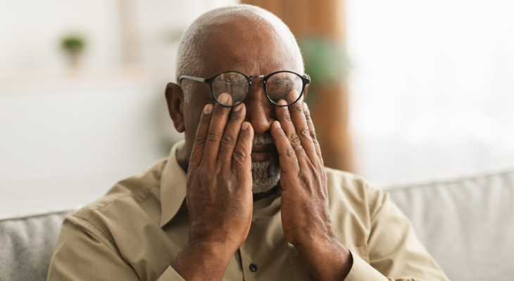 Old man rubbing his eyes