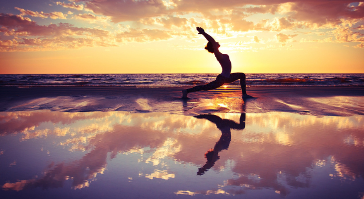 Woman does tranquil beach yoga