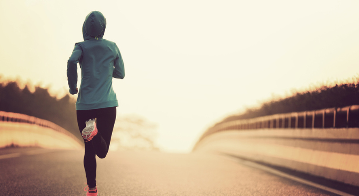 Woman runs along lonely road.