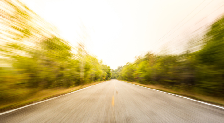 Blurry country road from driver's point of view.