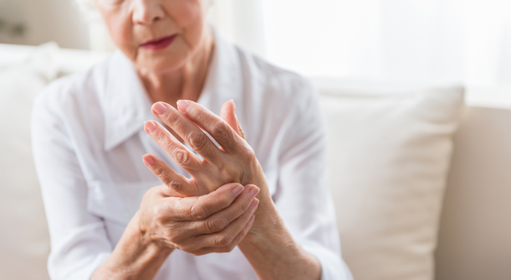 Old woman holds her own hand