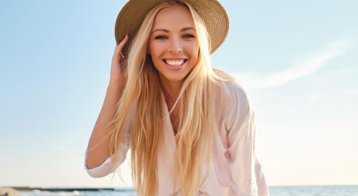 Woman smiles on the beach.