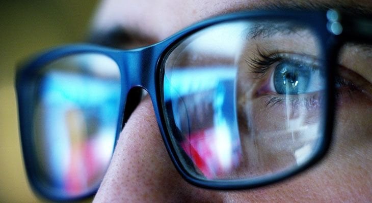 Man with glasses looking at computer