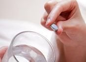 hand holding pill and glass of water, Oral sedation dentistry Baton Rouge, LA dentist