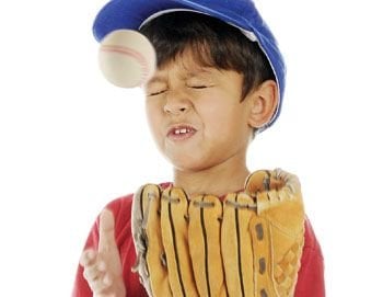 young boy wearing baseball glove and hat, getting hit in face by ball, emergency dentistry Baton Rouge, LA dentist 