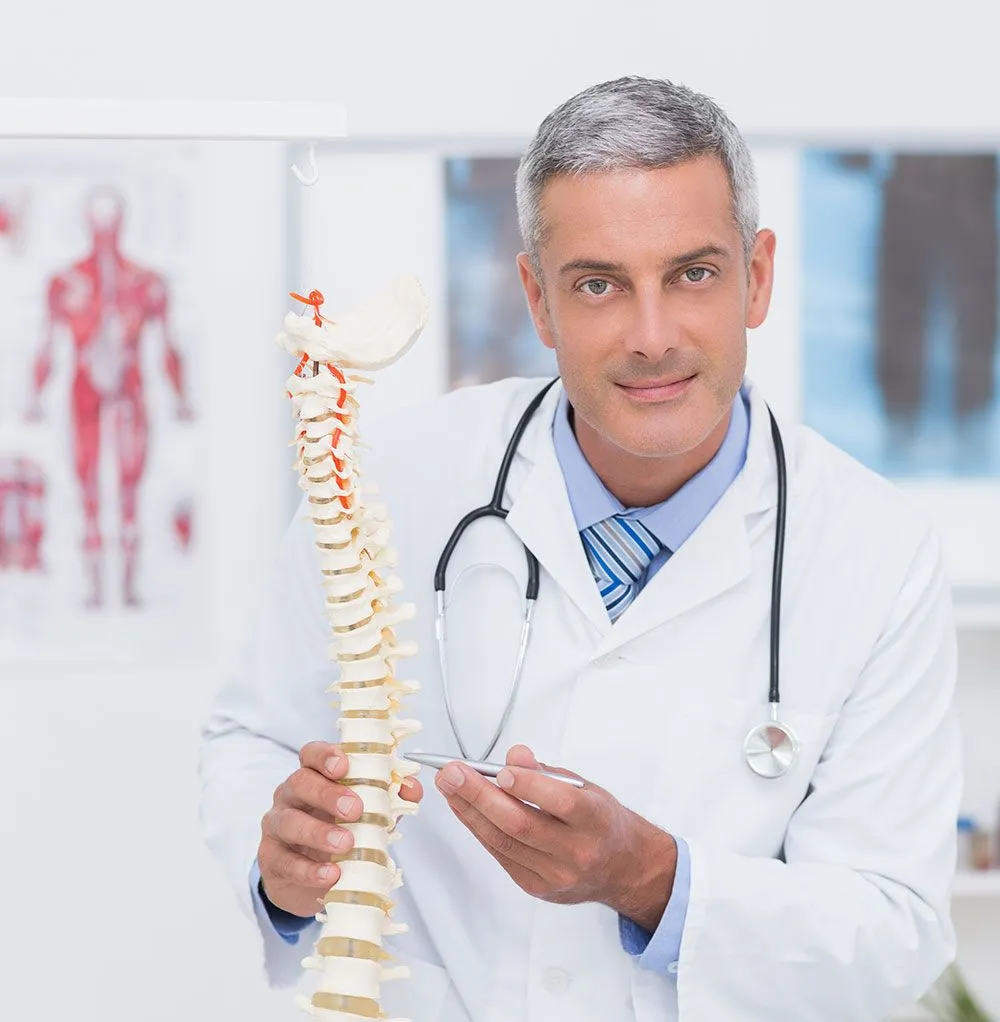 Smiling chiropractor with model of spine.