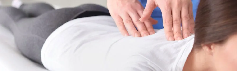 Physical therapist performing manual therapy on patient's shoulder at Ma Kao Rehabilitation in Flushing NY