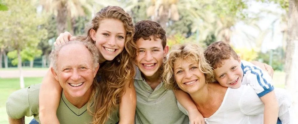 family outdoors posing and smiling for photo, cosmetic dentistry Millbrae, CA