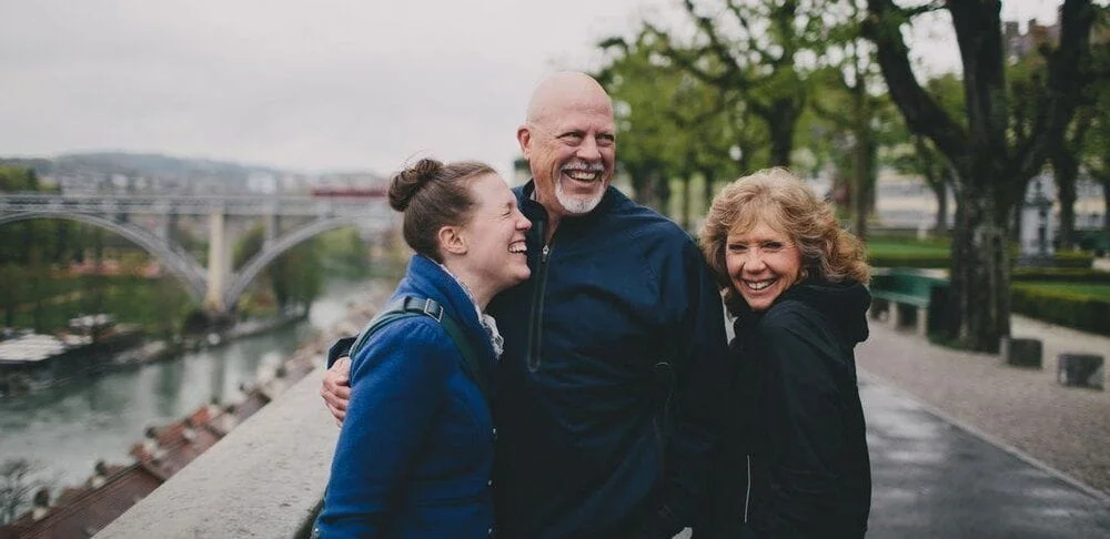 Family hugging out while walking with bridge in background scenery
