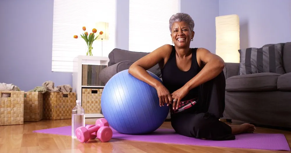 Woman sitting next to exercise ball