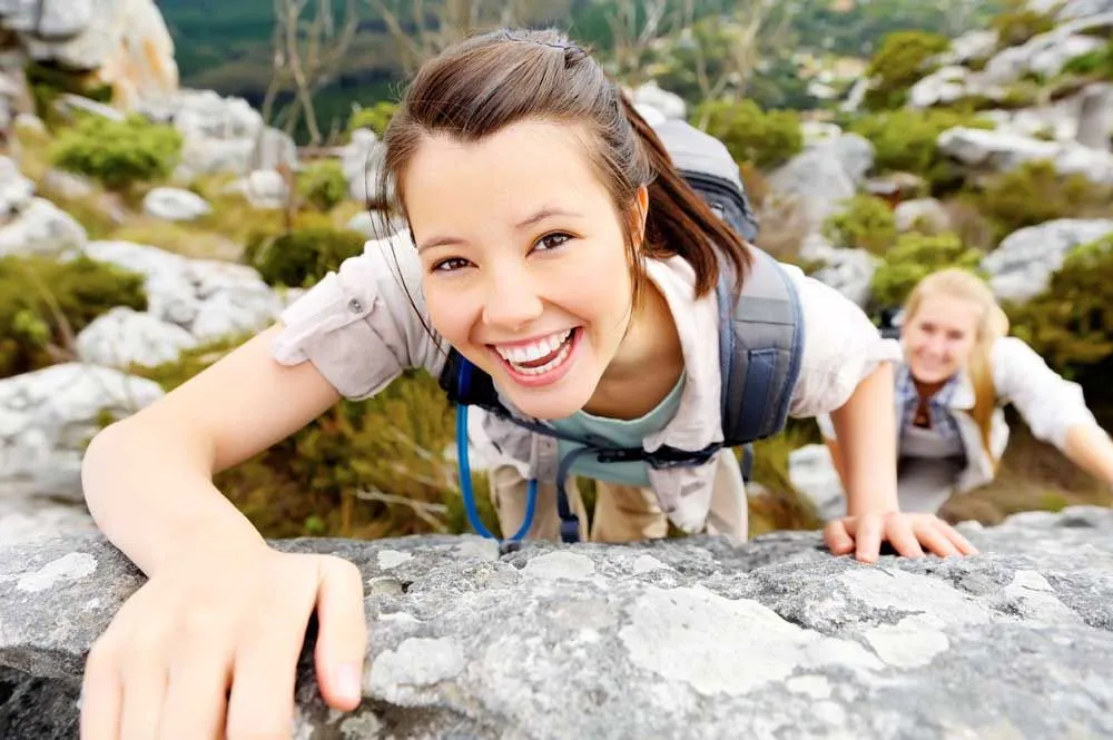 Woman rock climbing with her friend.