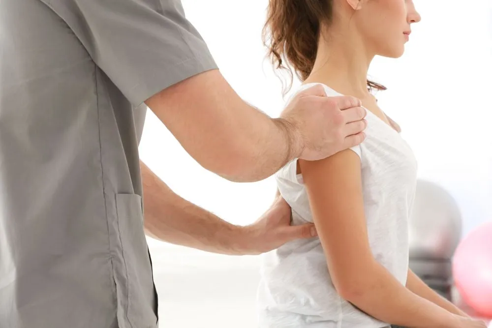 Woman getting checked for back pain.