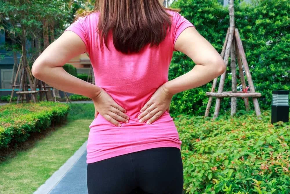 Woman with lower back pain in Kenosha, WI.