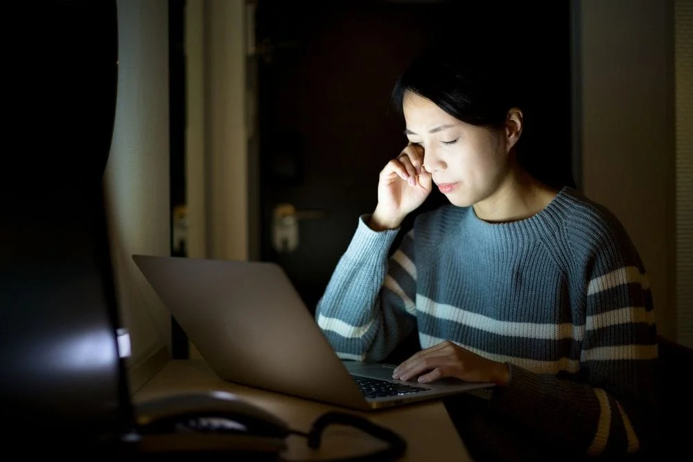 Woman with eye strain from staring at computer screen too long