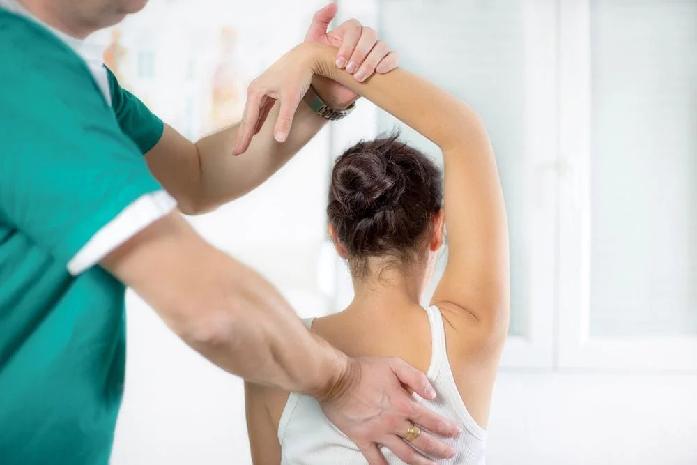 Woman with shoulder pain getting chiropractic care.