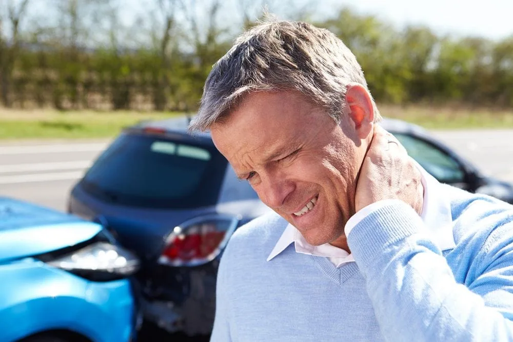 man holding neck from whiplash pain from an auto injury accident