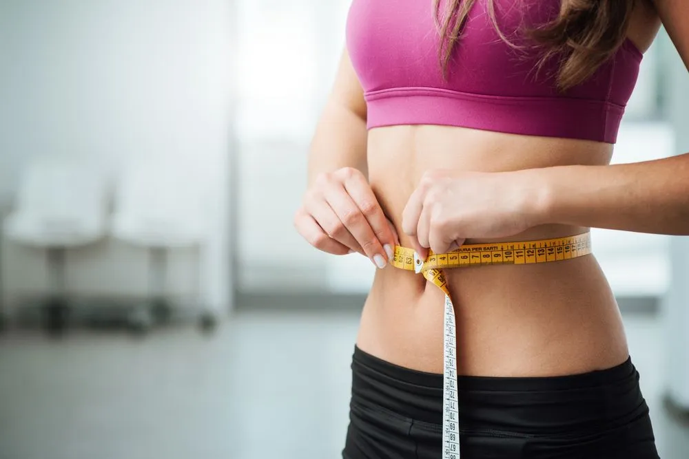 Woman measuring her weight loss progress in Irving, TX.