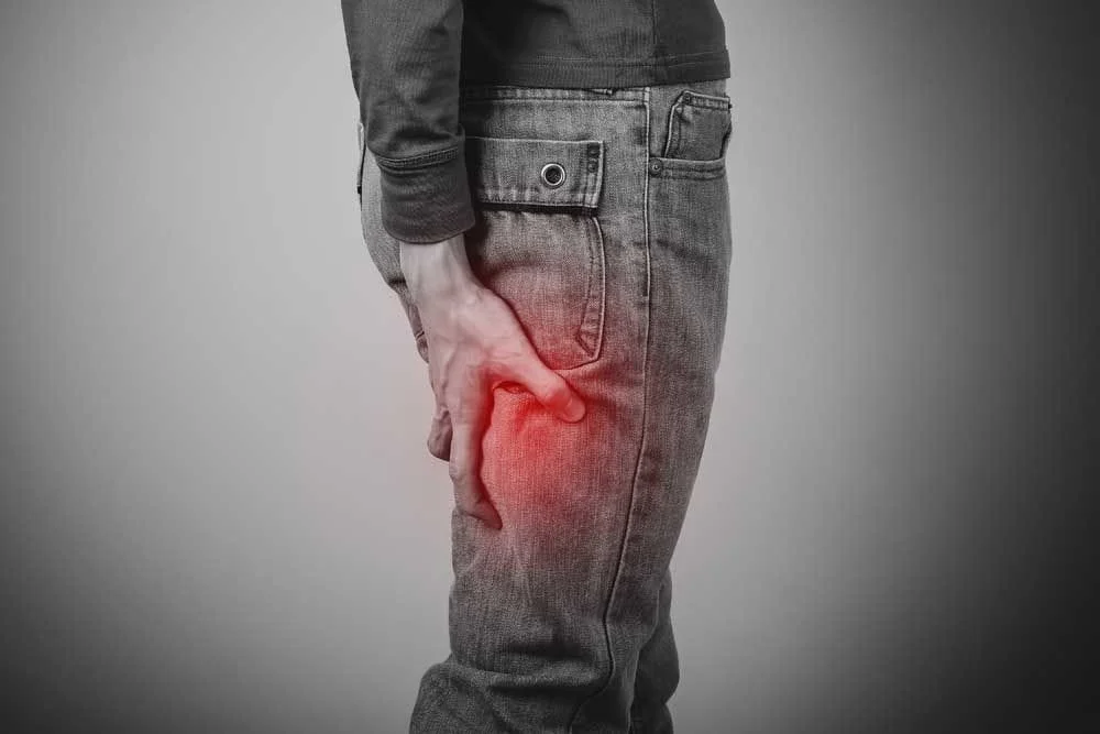 man holding the back of his leg from sciatica pain