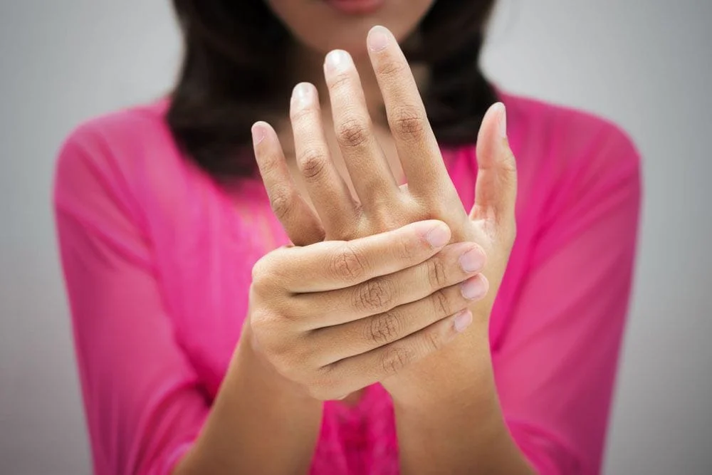 Woman experiencing hand pain should seek chiropractic treatment