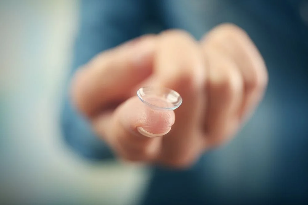 Woman holding her specialty contact lenses for Astigmatism.