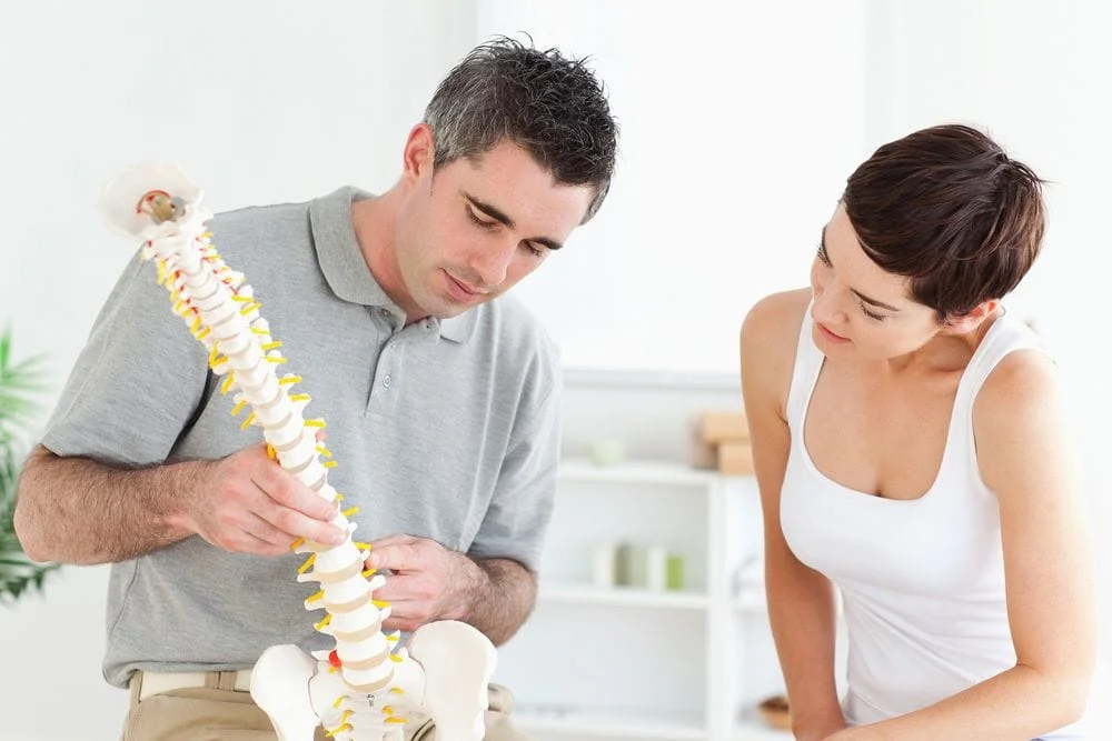 chiropractor with a spine model and client in Thousand Oaks, CA