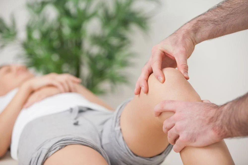 Woman with knee pain getting chiropractic care.
