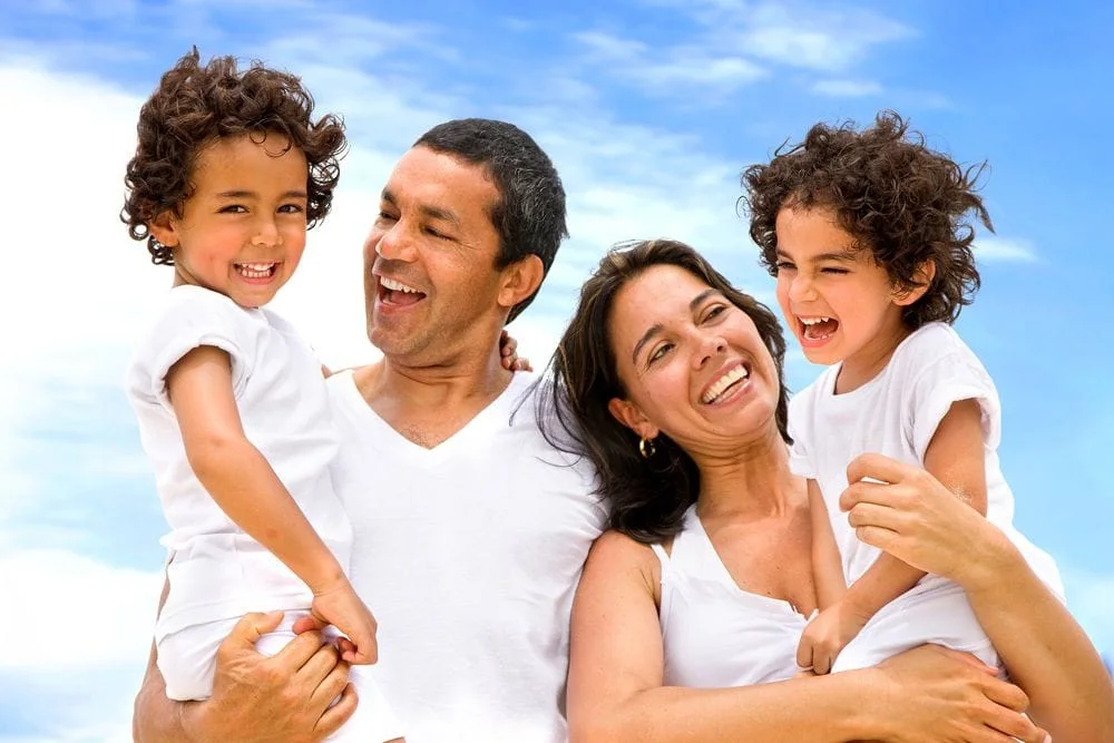 Parents holding their two kids love visiting the chiropractic for a safer, more optimal health lifestyle