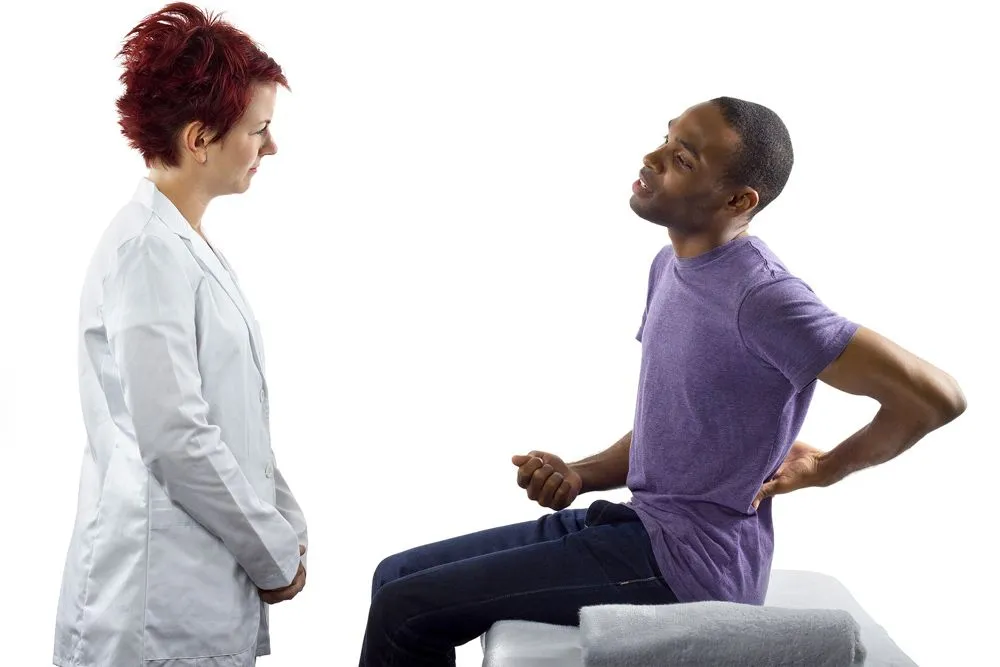 chiropractor talking to a patient who was injured during a sporting event