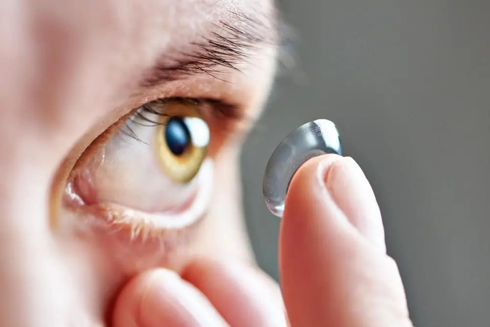 woman putting in a contact lens in West Des Moines