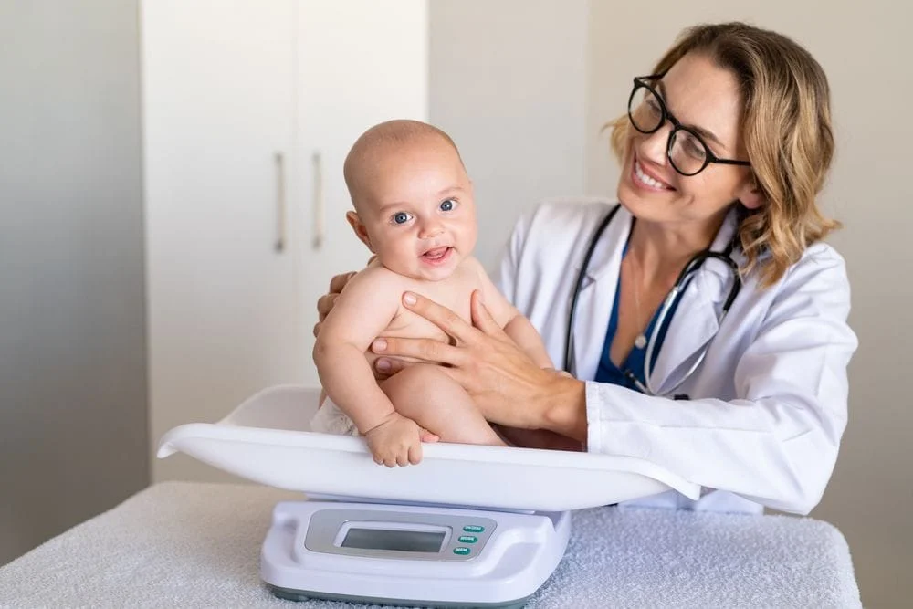 Infant Being Weighed By Doctor