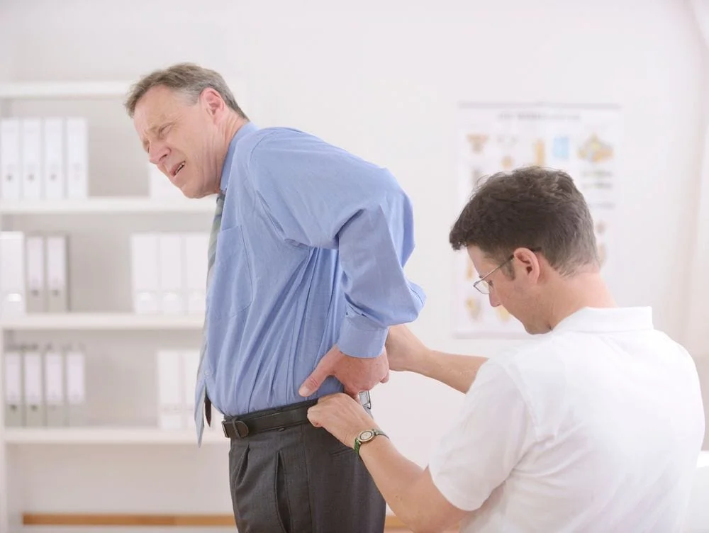 chiropractor and patient during a chiropractic adjustment for a spinal injury