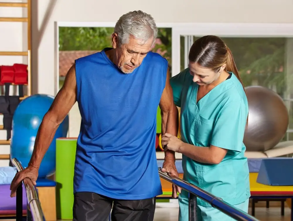 man recieving physical therapy treatment from aide at Queens Chiropractic